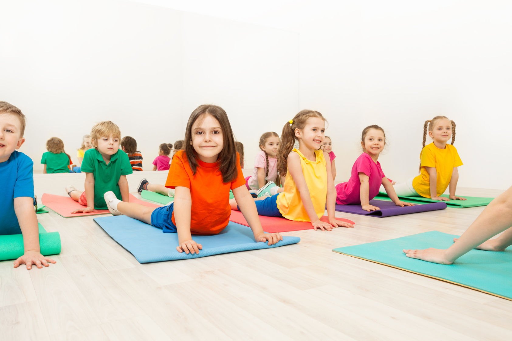 Kids Stretching Backs on Yoga Mats 